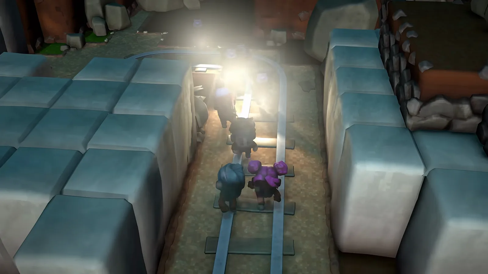 Inmates walk single file along rail tracks through a torch-lit stone underground in The Escapists 3, matching the confirmed catacomb escape zone