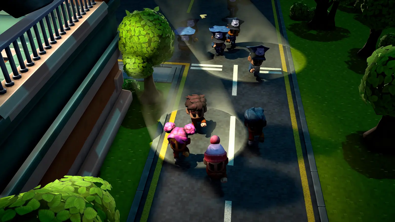 Official The Escapists 3 press screenshot of guards sweeping overlapping flashlight cones along a night street while four inmates hug the wall outside the beams